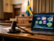 En domarklubba bredvid en bärbar dator med suddiga bannerannonser, som symboliserar domstolens beslut om spelreklam.